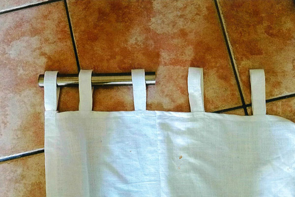 A white caravan curtain on its rod